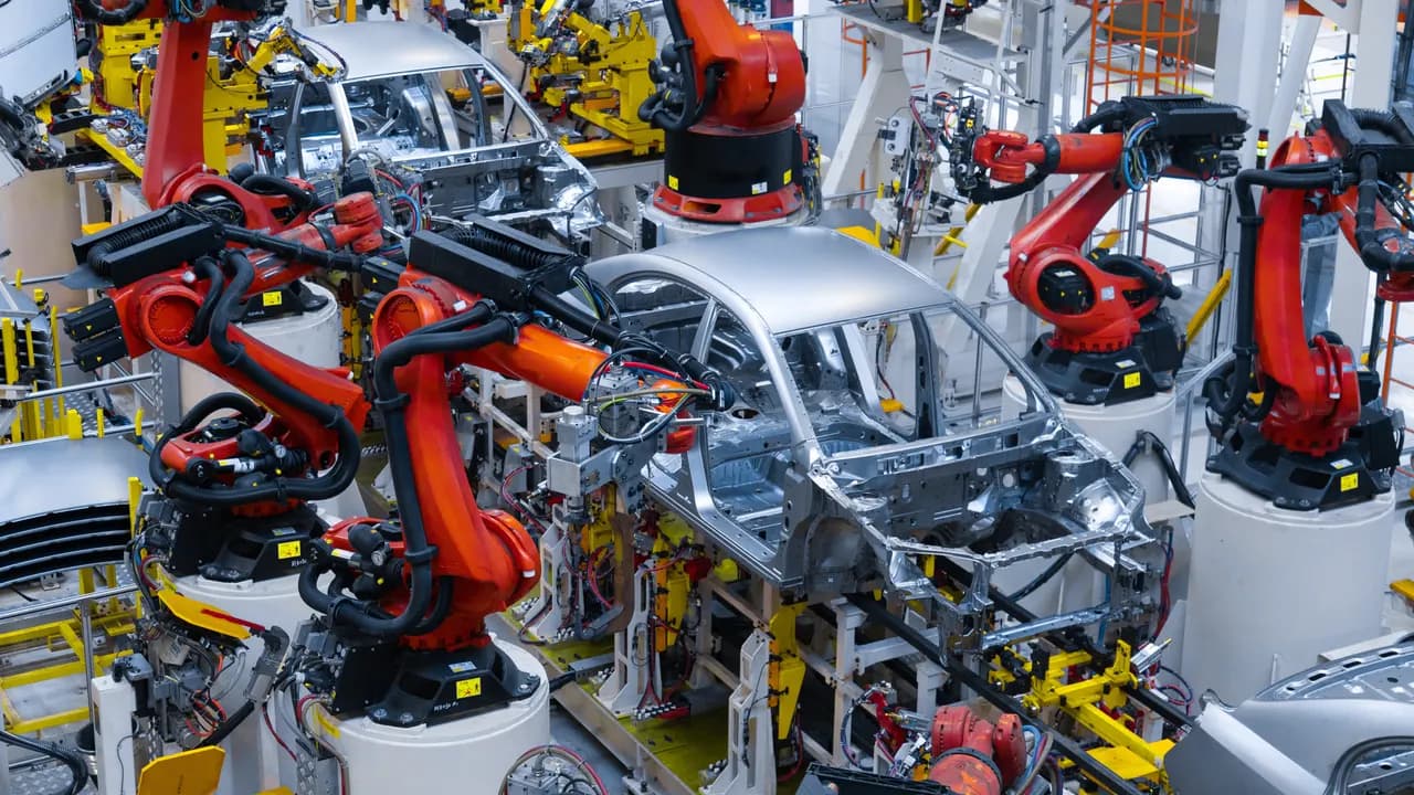 Modern automotive production with industrial robots — symbolic image for outplacement in the automotive industry