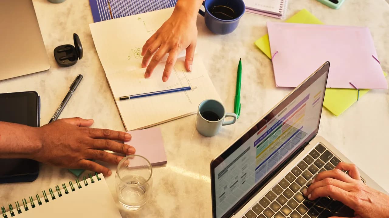 Team am Schreibtisch mit Laptop und Analytics-Dashboard – Symbolbild für Outplacement in Medien und Marketing